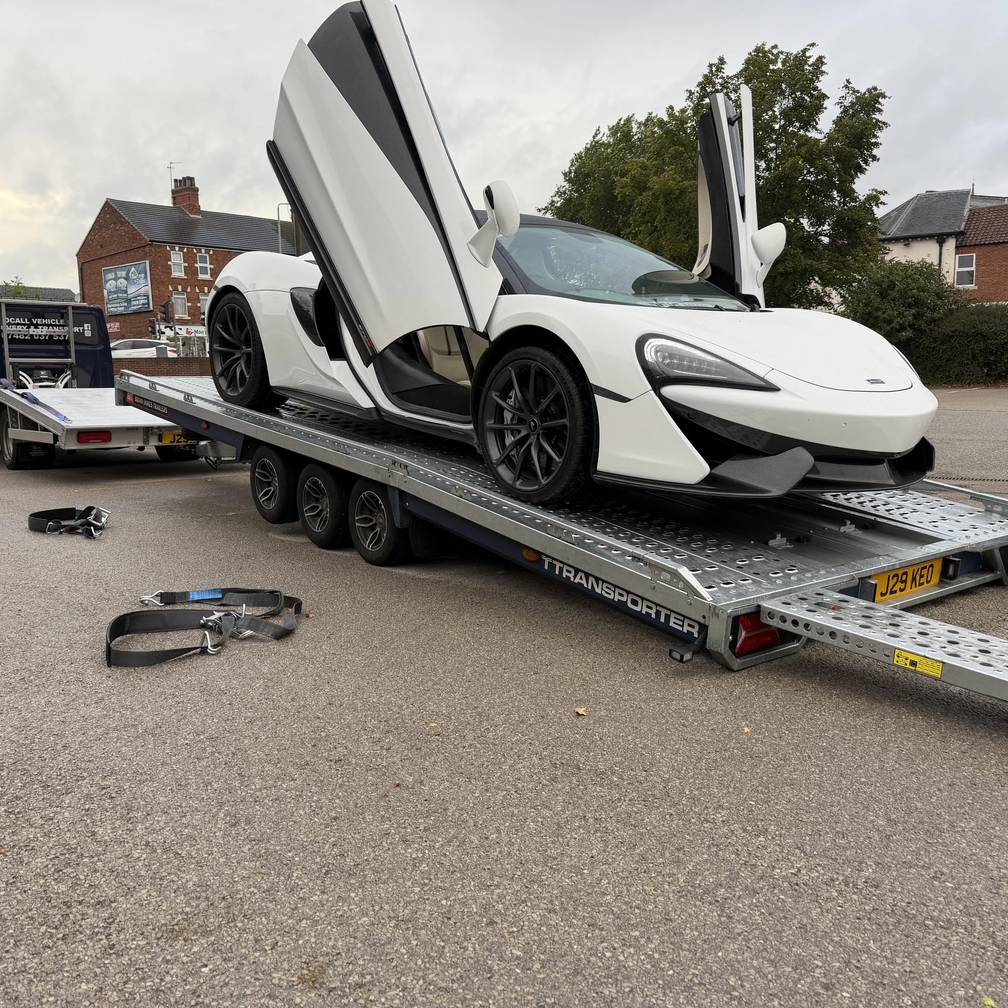 A white supercar loaded onto an Ocall recovery truck