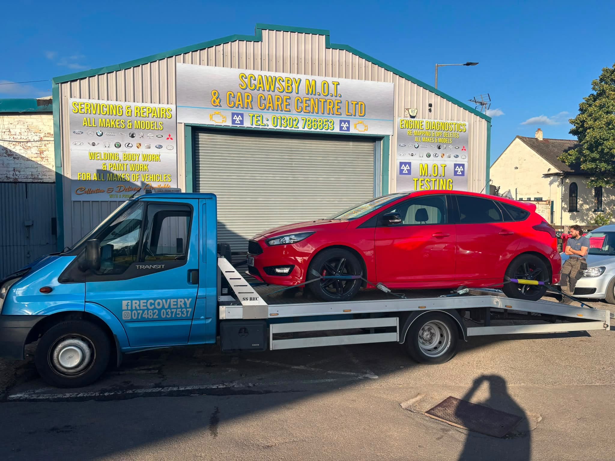 A red car secured on an Ocall recovery truck